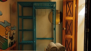 Een kamer met een bed, een blauwe garderobe en een houten deur.