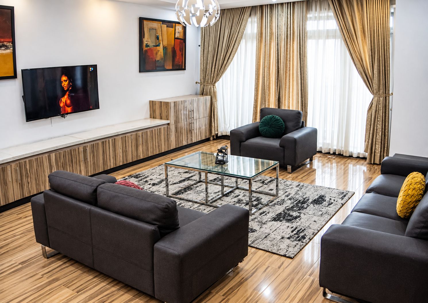 Una sala moderna con un juego de sofá, una mesa de centro y un televisor montado en la pared.