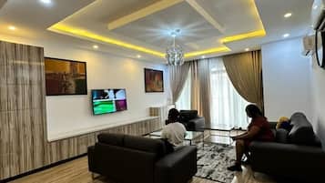 Departamento de lujo, para no fumadores, baño en la habitación | Área de sala de estar | Smart TV de 50 pulgadas con canales por cable y televisión