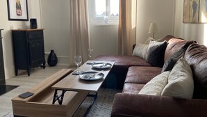 Un salón moderno con una mesa de centro de madera, un sofá de cuero marrón y un mueble negro.