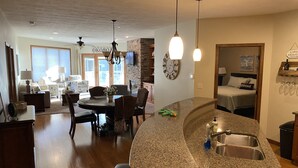 A modern kitchen with granite countertops, a built-in sink, and a dining area with a round table and chairs. - Relaxing Getaway, Lakeside Sunsets, 6 Waterpark passes, Memories Galore!! (Arnolds Park)
