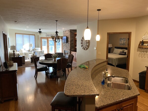 A modern kitchen with granite countertops, a built-in sink, and a dining area with a round table and chairs.