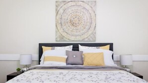 A neatly made bed with a floral-patterned bedspread, a headboard with a circular design, and two bedside lamps on either side.