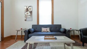 A living room with a sofa, coffee table, and two side tables.