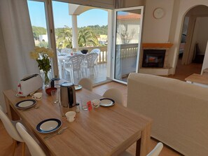A dining area with a table set for two, a toaster, a kettle, and a vase with flowers. - Well located single storey villa near Cala Montgo. (L'Escala)