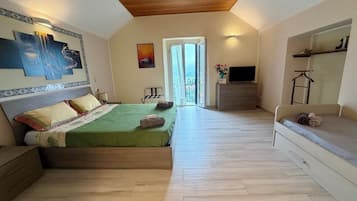 Ein Schlafzimmer mit einem Bett, einem Fernseher und einem Balkon.