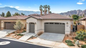 A residential house with a tiled roof, two garages, and a landscaped front yard with small trees and shrubs. - Signature View! Gorgeous BRAND NEW Home (Misters!) (La Quinta)