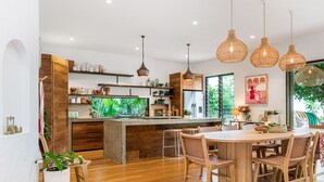 Une cuisine moderne avec des meubles en bois, un îlot central et des luminaires suspendus.