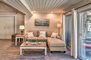Relax in this cozy living space with a large sofa, wooden coffee table, and floor lamps.