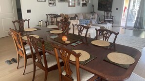 A dining area with a large wooden table, chairs, and a chandelier. - One block from Beach. Spacious 2 bedroom apartment BTR #2197 (Indian Rocks Beach)