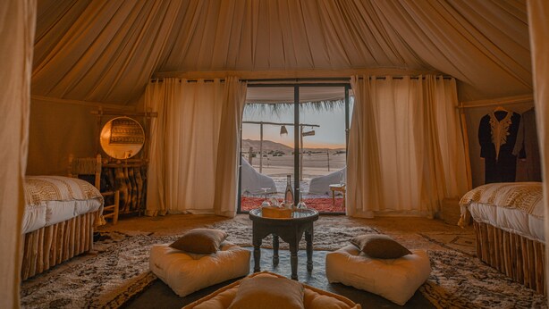 A tented room with two beds, a round table, and a view of the desert. - Imperial Glory Lodges (Rissani)