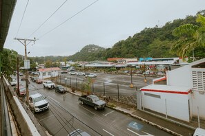 A parking lot with vehicles and a building with a red roof.