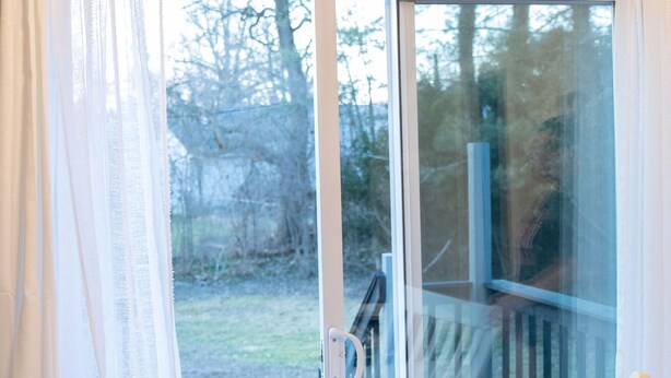 Ein Zimmer mit einer Schiebetür und Zugang zu einer Terrasse.