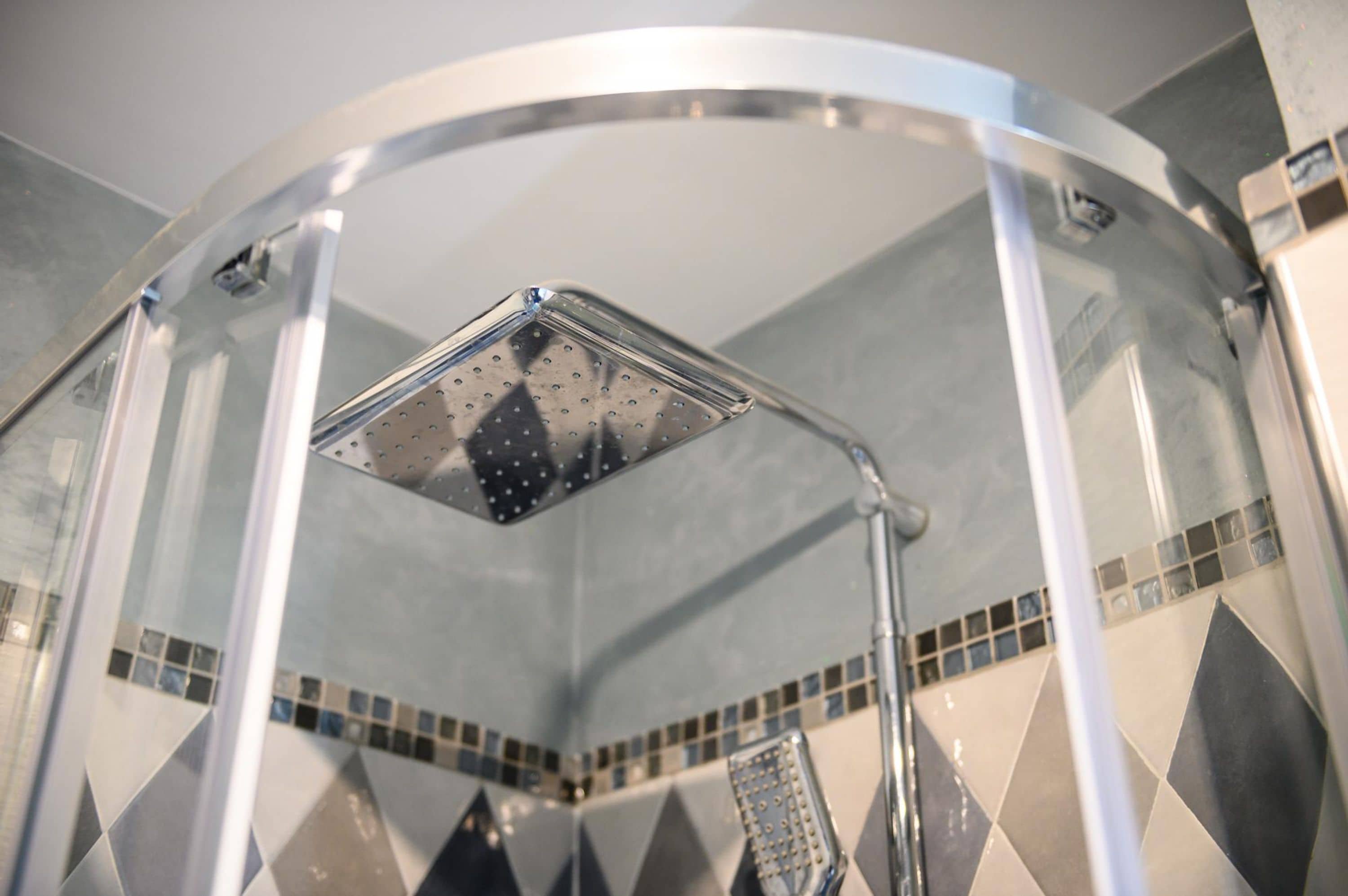 Een douche met een glazen cabine en een handdouche.