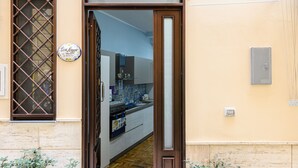 A doorway leading to a kitchen with a tiled backsplash and wooden flooring. - Casa Maggio in Vietri sul Mare (Vietri sul Mare)