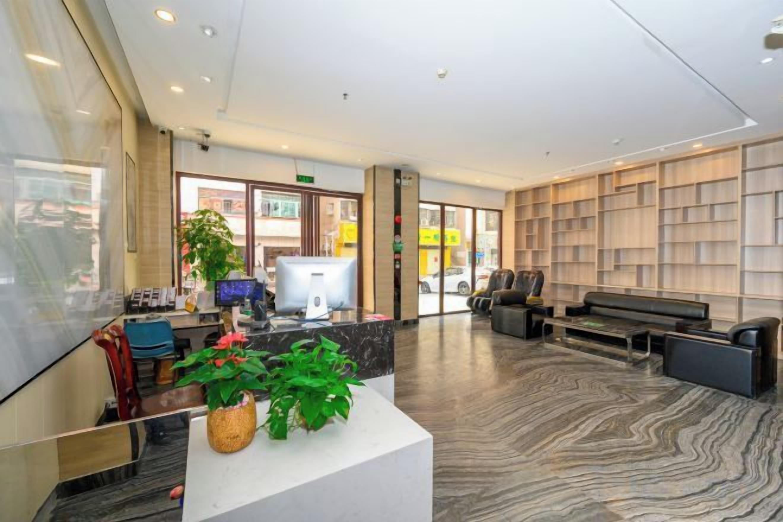 A reception area with a reception desk, seating area, and a large bookshelf.