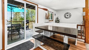 A modern kitchen with a dark wooden table and white cabinetry. - Lakefront Cabin, Hot Tub, Sauna, Fireplace, Game Room, Near Duluth  (Saginaw)