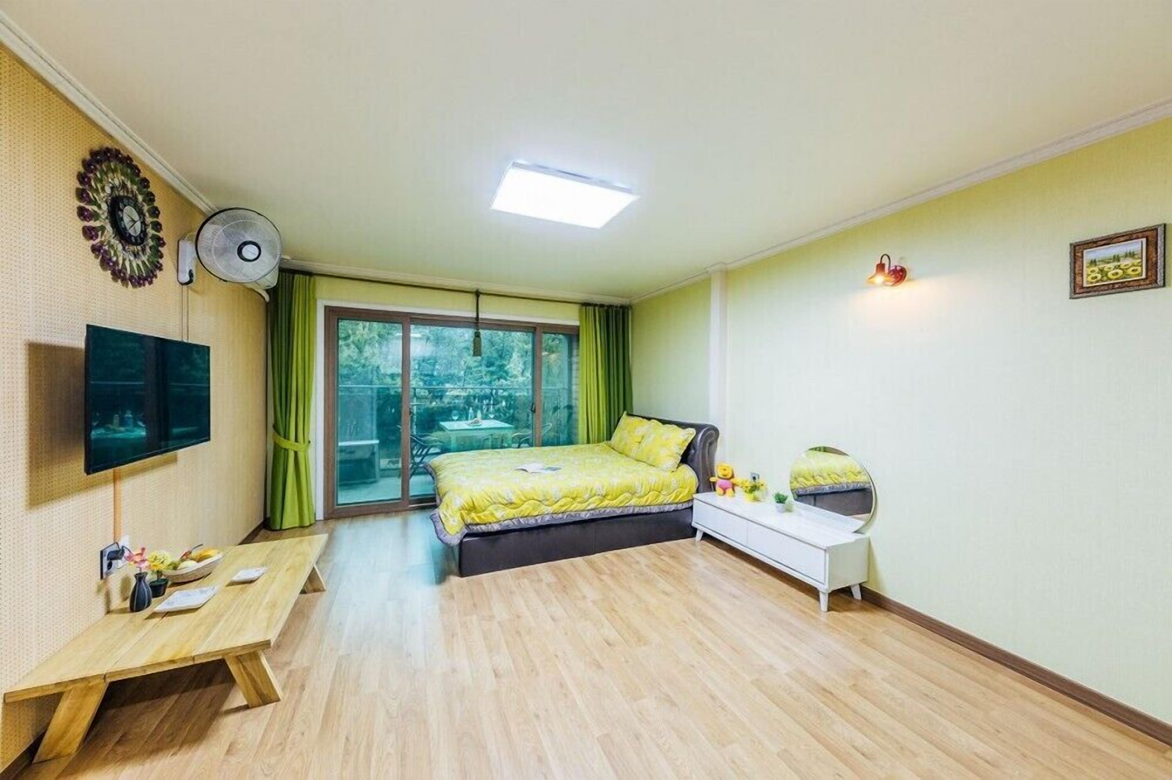 A bedroom with a bed, bedside table, and a TV.