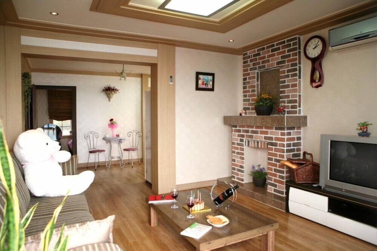A cozy living room with a fireplace, a sofa, a dining area with chairs, and a television.