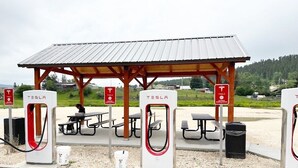 A Tesla charging station with picnic tables and a covered shelter. - Johnny Cash "The Rambler" Suite on Main - walking distance to all stores and food! (Custer)