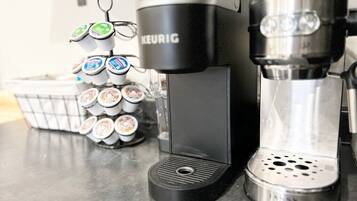 Une machine à café de la marque Keurig, un support pour dosettes de café et une machine à café à filtre.