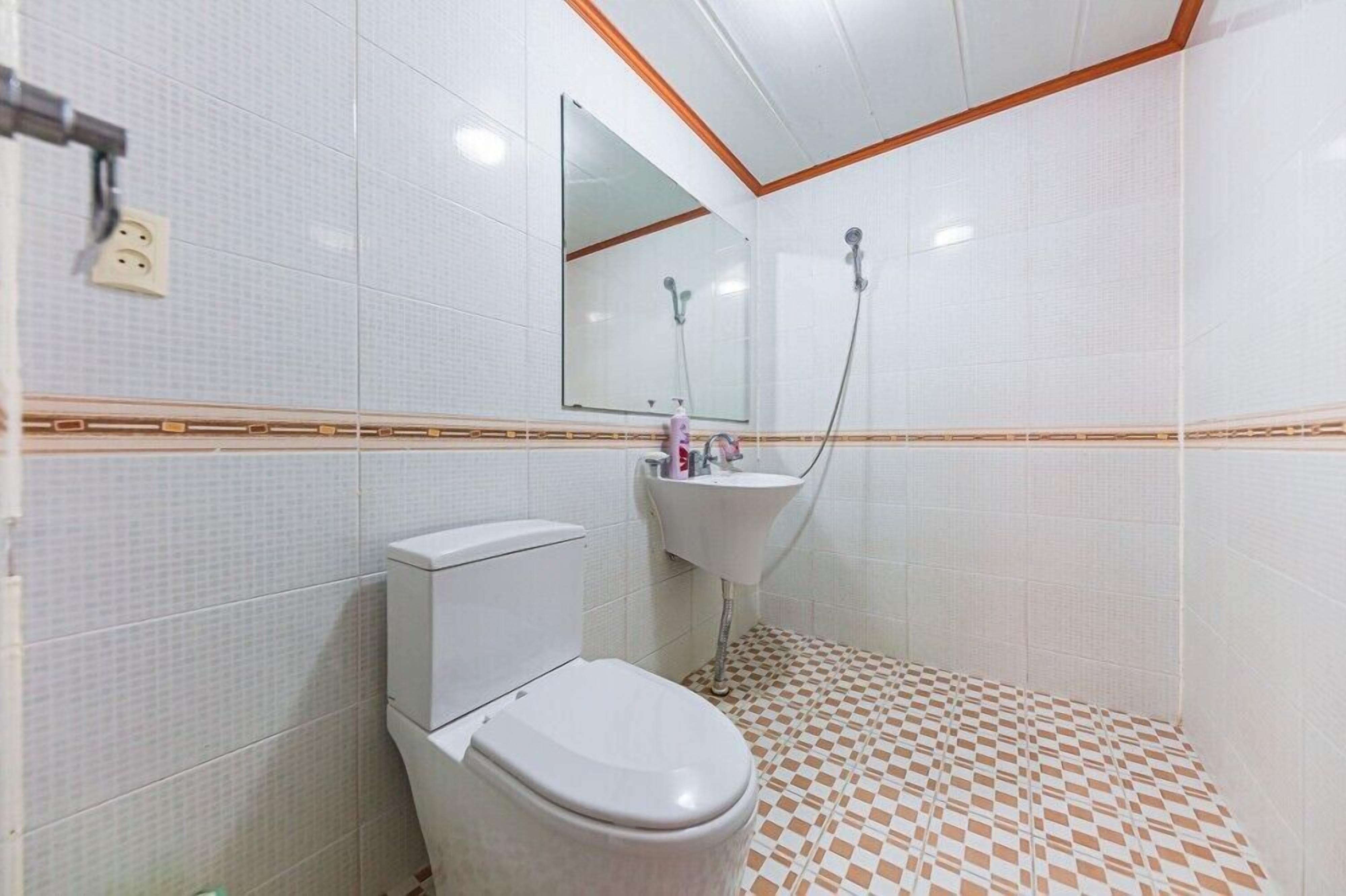 Een badkamer met toilet, wastafel en douche.