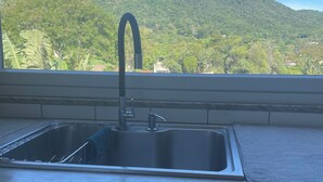 Eine Küche mit Spüle aus Edelstahl und einem Fenster mit Blick auf eine Berglandschaft.