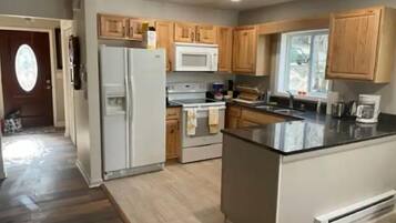 Una cocina moderna con armarios de madera, un refrigerador, un microondas y una estufa.