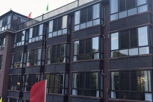 A multi-story building with a modern architectural design, featuring a series of windows and balconies.