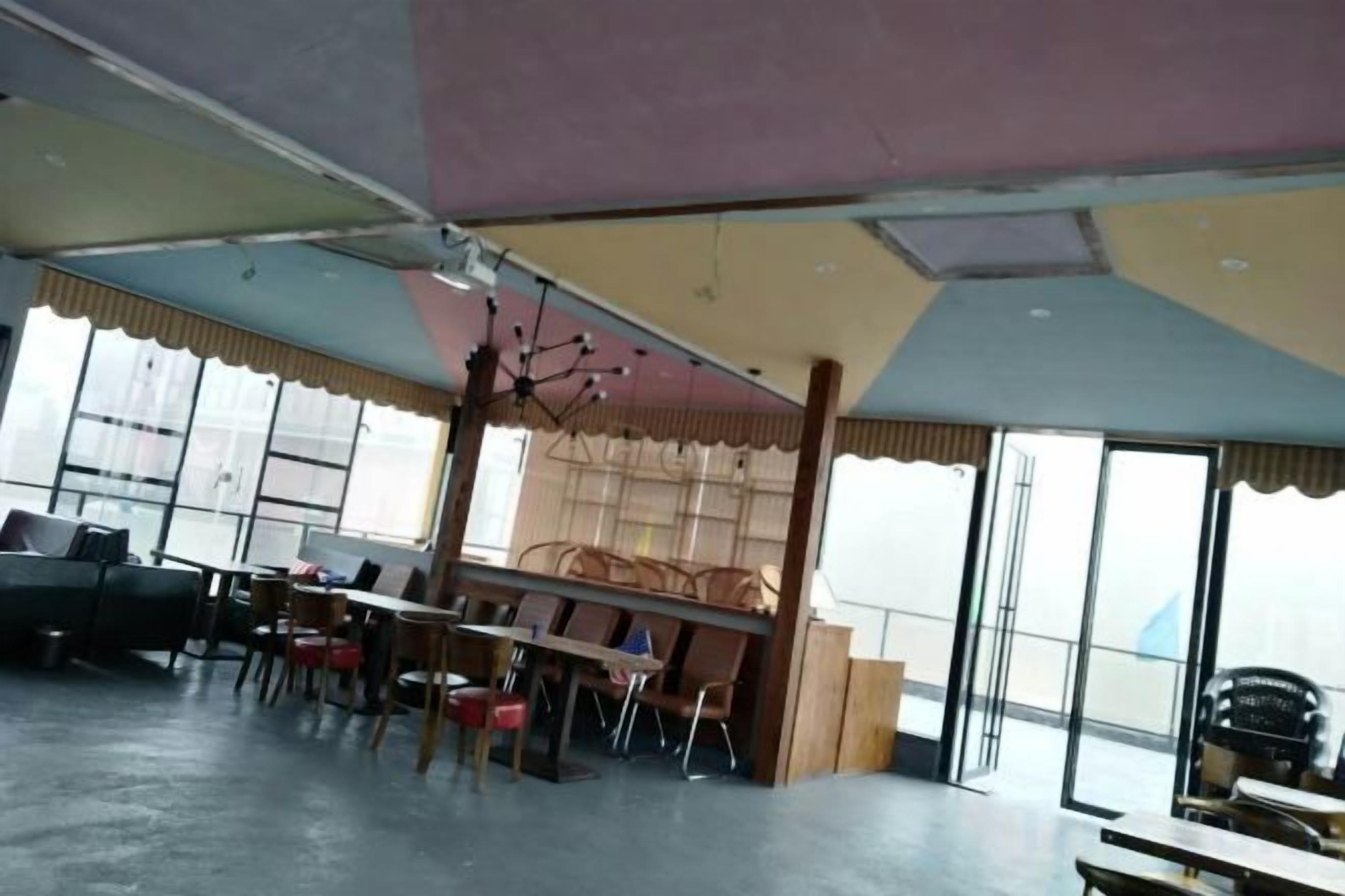 Una habitación con una mesa grande, sillas y vistas a través de las ventanas.