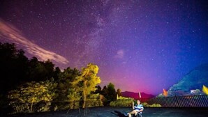 A person sitting on a chair under a starry sky. - Senlinli Campsite (Zixing)