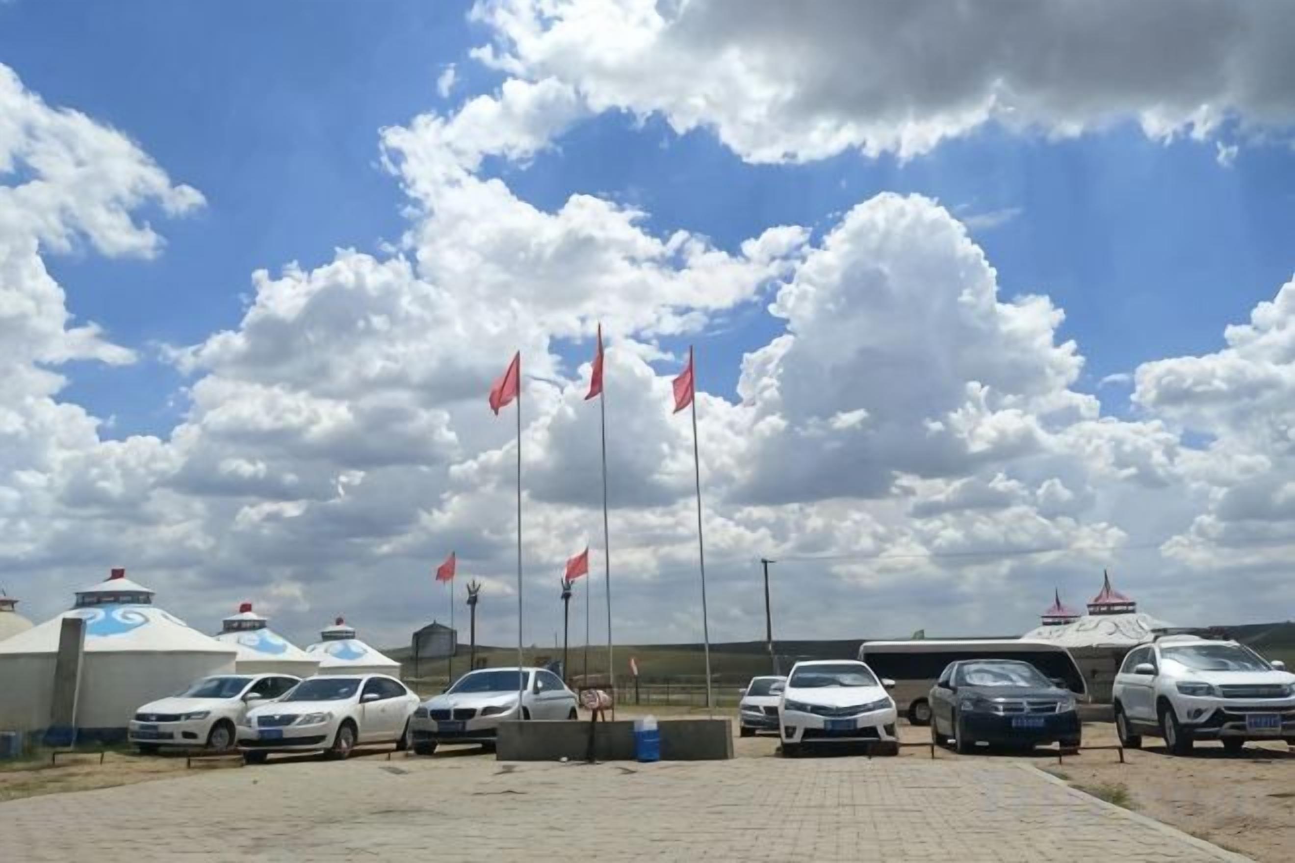A parking area with several cars and a building with a blue roof.