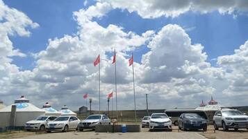 A parking area with several cars and a building with a blue roof.