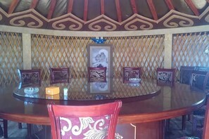 A round dining table with chairs, framed pictures on the wall, and a decorative ceiling. - Ulan tuya hosts tribes in the helamuren steppe (Damao Banner)