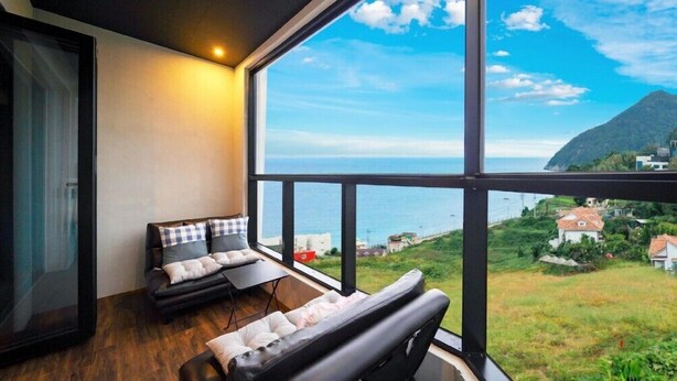A balcony with a view of the sea and a mountainous landscape. - Geoje Beans Pension (Geoje)