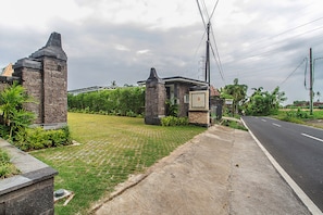 Enter a serene oasis surrounded by lush greenery and a beautifully manicured entrance.