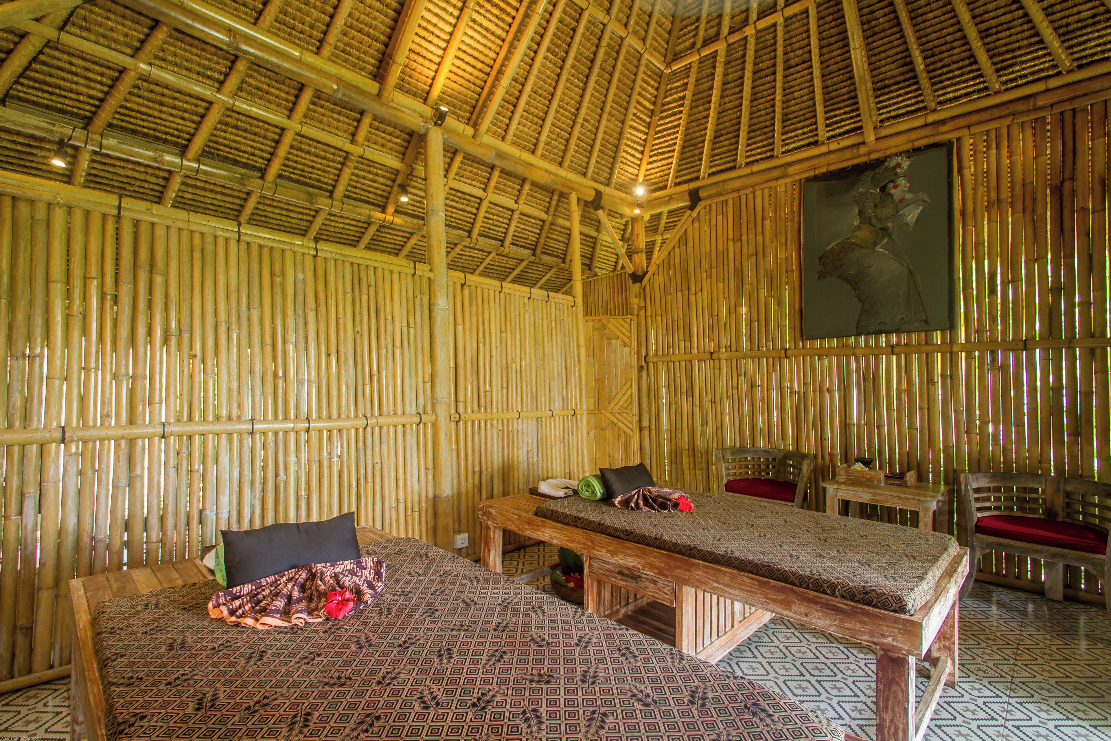 Una habitación con dos camas, un banco de madera y una mesa.