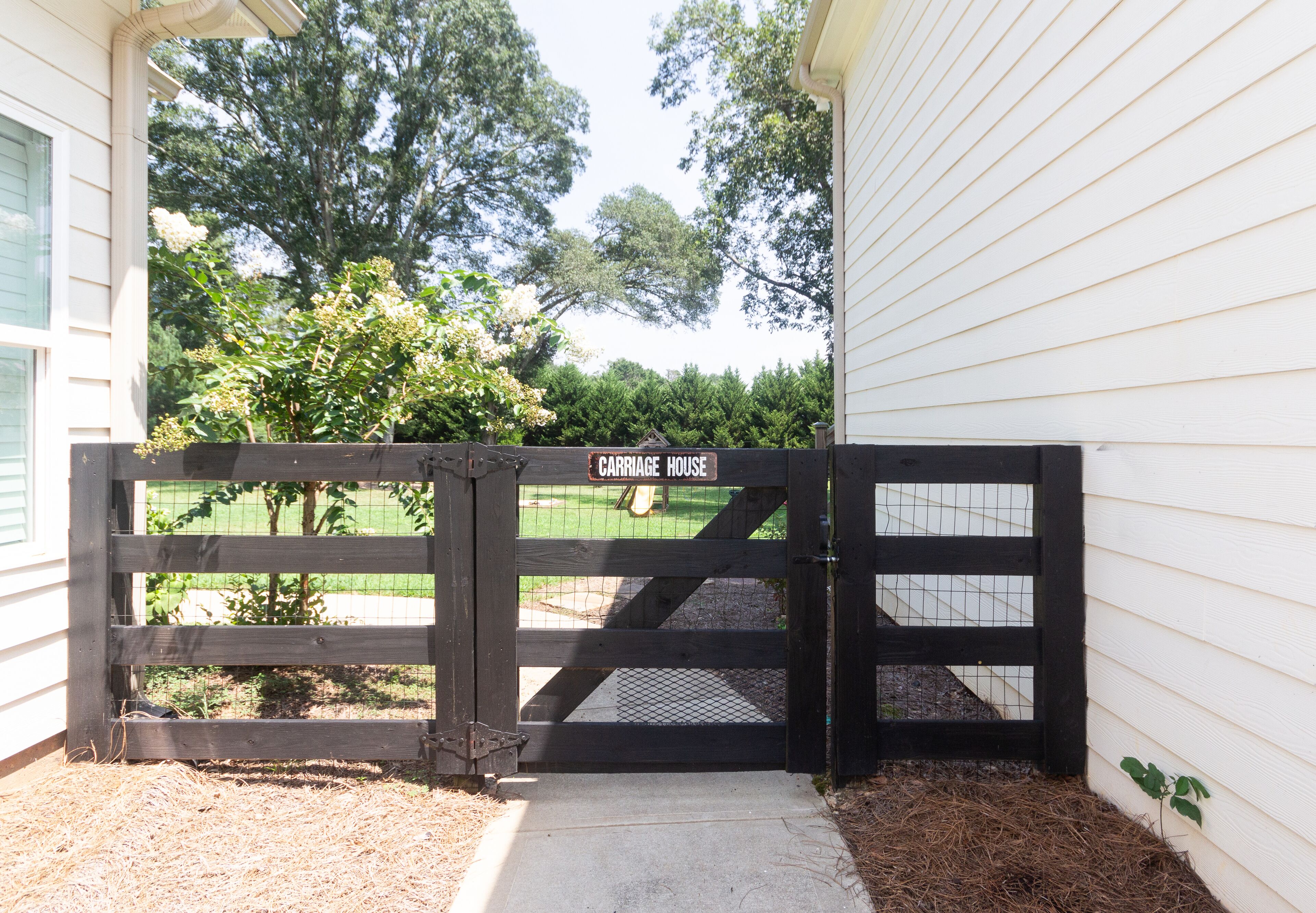 A gated entrance to a property with a sign reading "Carriage House."
