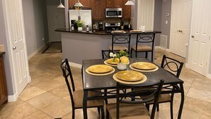 A modern kitchen with a central island, dark countertops, and wooden cabinets. - Sunset Lake House 304 (Willis)