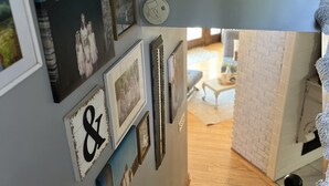 Un escalier avec une rampe, un mur orné de tableaux encadrés et un panneau indiquant : « toujours efficace ».