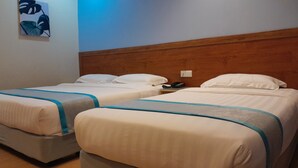 A hotel room with two beds, each with a wooden headboard and white bedding. - TD CAPITAL HOTEL (Kota Kinabalu)