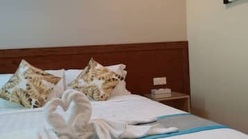 Una habitación de hotel con una cama bien hecha, un cabecero de madera y una obra de arte colgada en la pared.