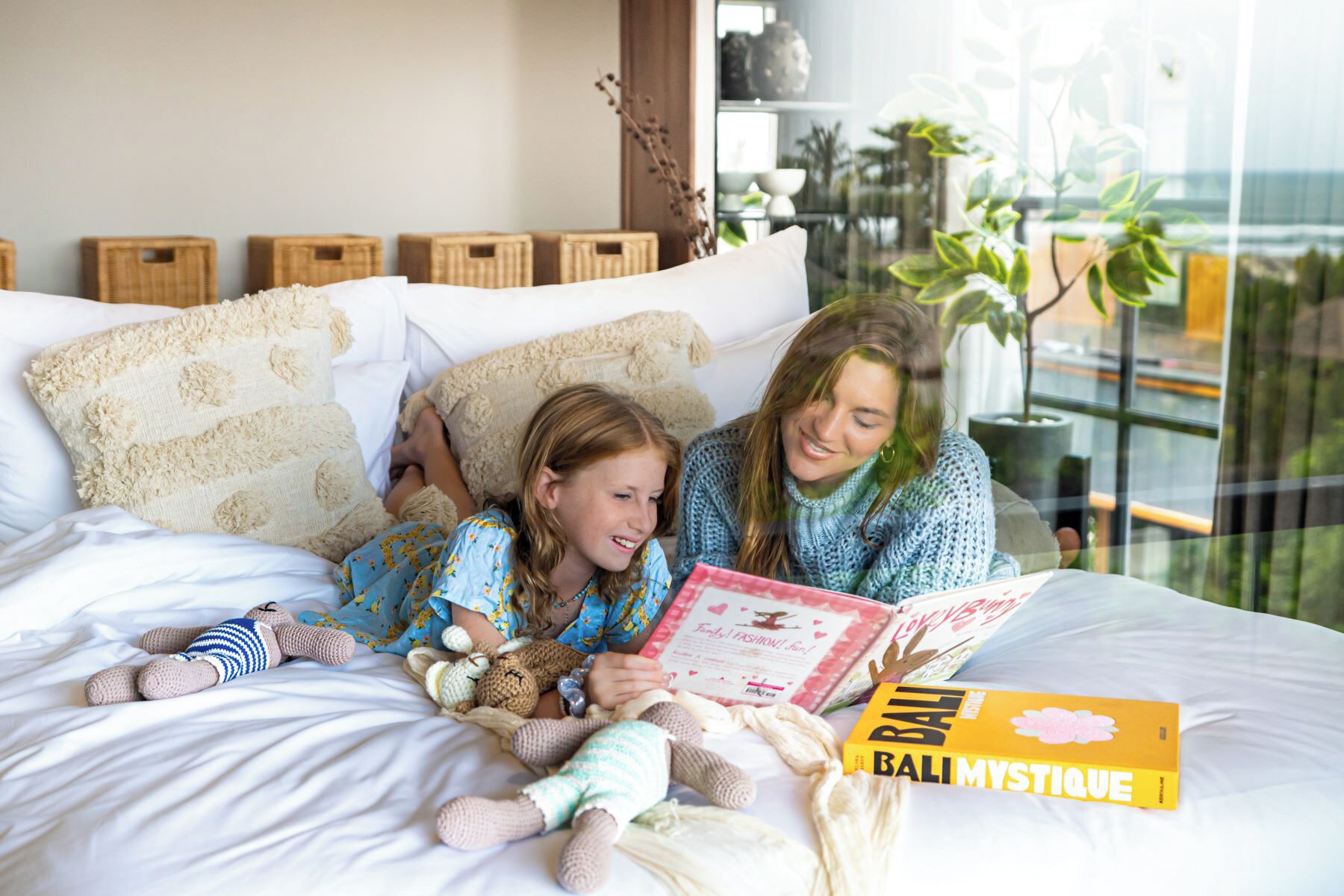Een slaapkamer met een bed, kussens en een raam met uitzicht.