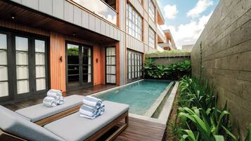 A modern outdoor pool area with lounge chairs and a wooden deck.
