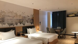 A hotel room with two beds, a desk, and a dining area. - Jinjiang Star Hotel (Pasay)