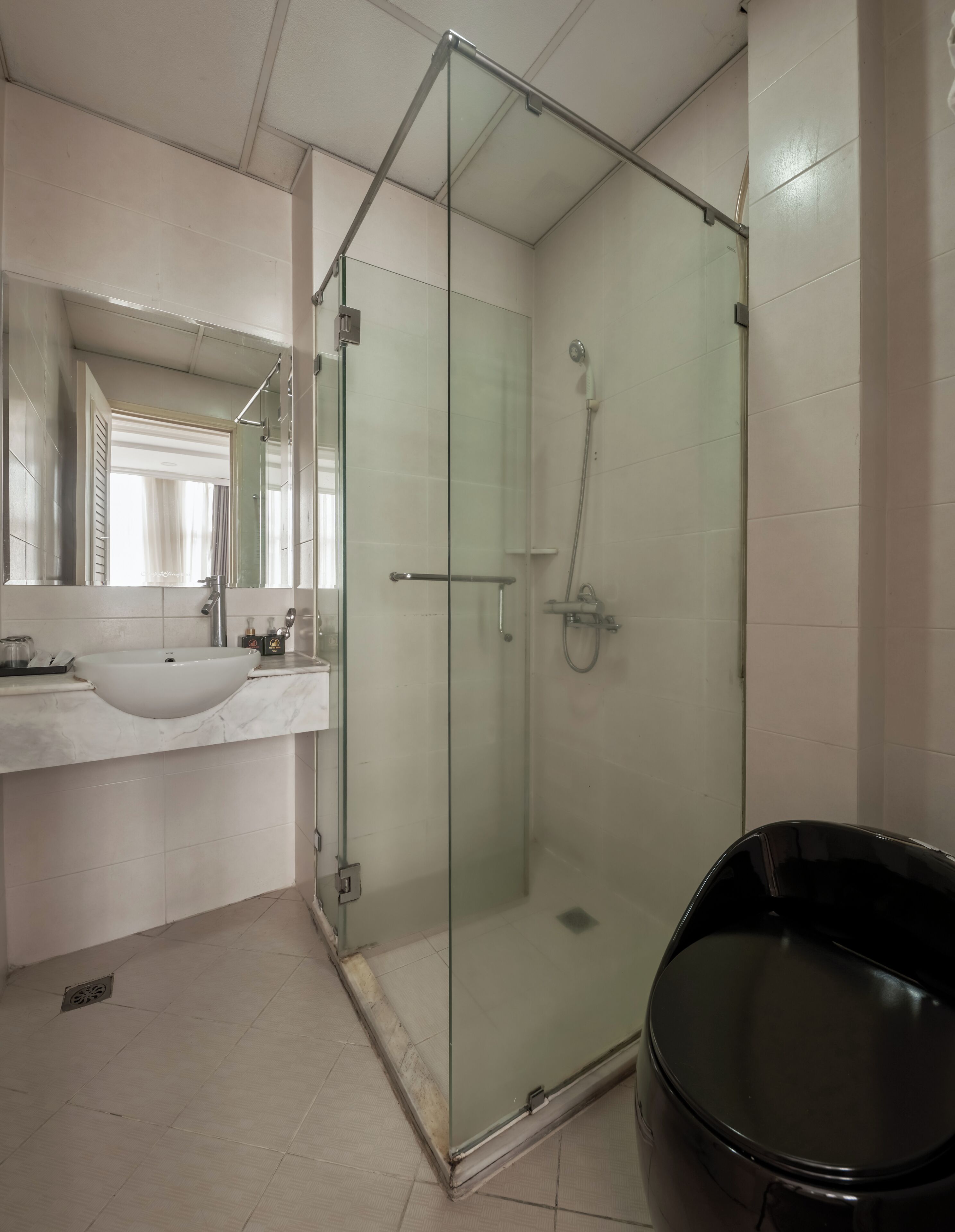 A modern bathroom with a glass-enclosed shower, a sink, and a bathtub.