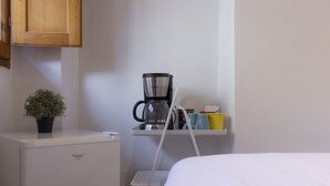 A compact kitchenette with a coffee maker, a small fridge, and a potted plant. - Chianti's Inn Trebbiano (Firenze)