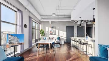 Un appartement moderne comprenant un coin repas, une cuisine et une grande fenêtre.