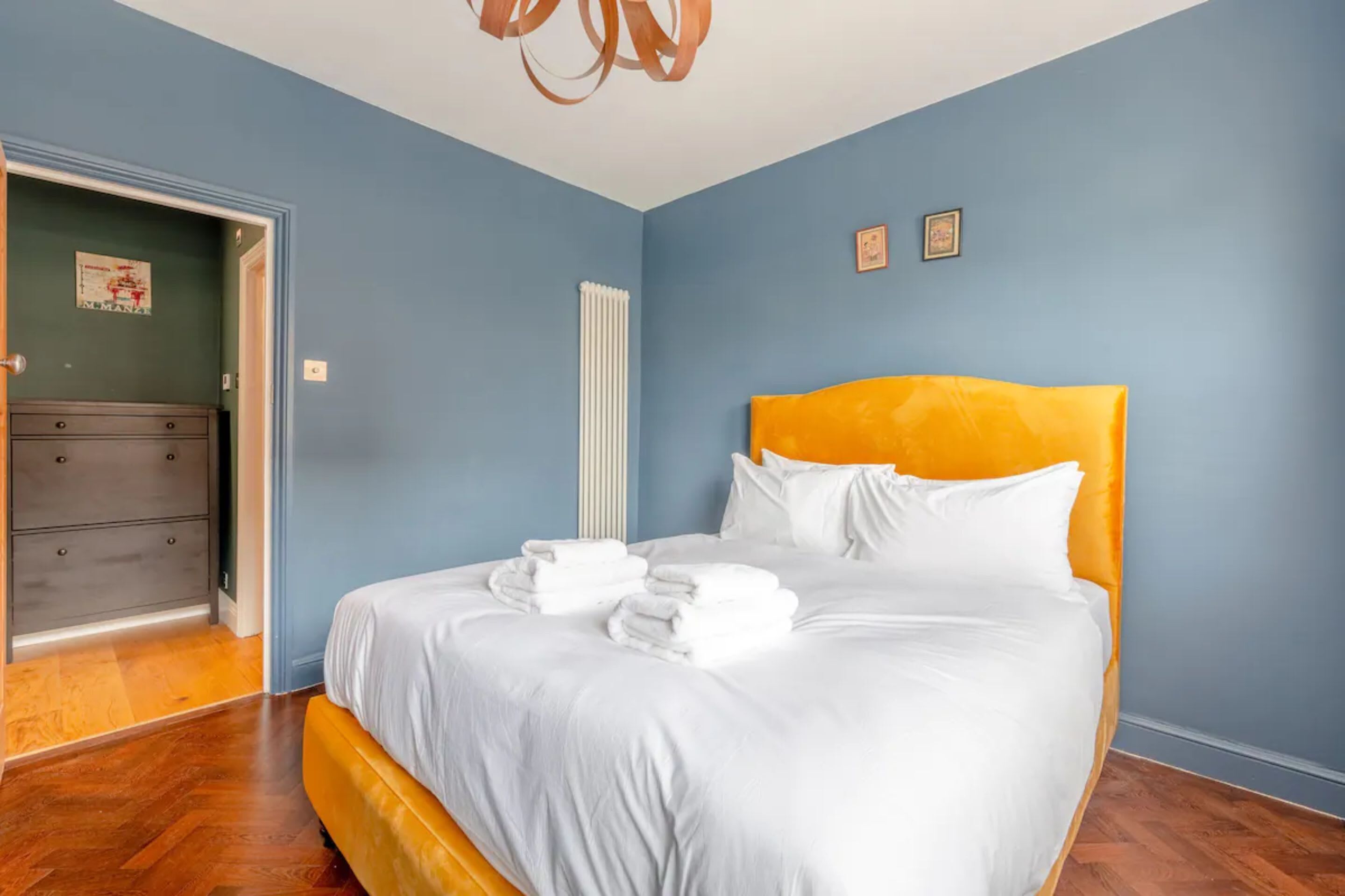 Un dormitorio con cama, cómoda y radiador.