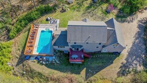 A house with a swimming pool, a covered patio, and a red-roofed deck. - Blueberry More Limit 17 7 Bedroom Home by RedAwning (Raymond)